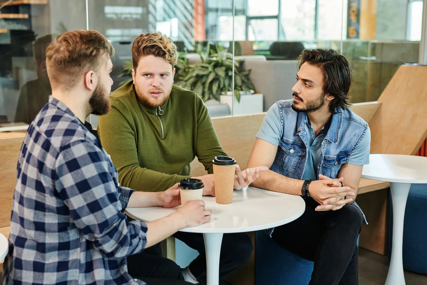 Three members talking over coffee